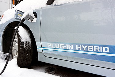 A photo of a plug-in electric vehicle charging in the snow.