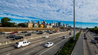 A photo of traffic on an interstate with a city in the background.